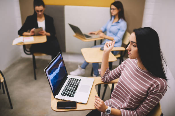 istock Female student working on laptop in modern class 1474175041