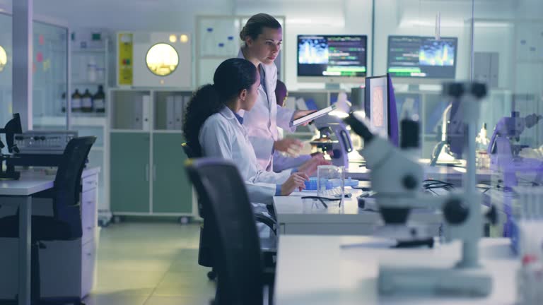 Women, science and employees in laboratory, talking or innovation for healthcare, discussion and technology. Female researchers, coworkers or scientists in lab, data analytics or medicine development