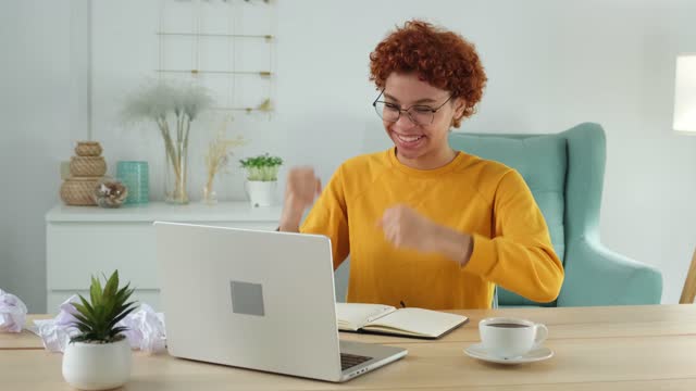 Excited happy african american woman euphoric winner. Girl student looking at laptop passed exam reading great news getting good result winning online bid feeling amazed at home. Winning gesture.