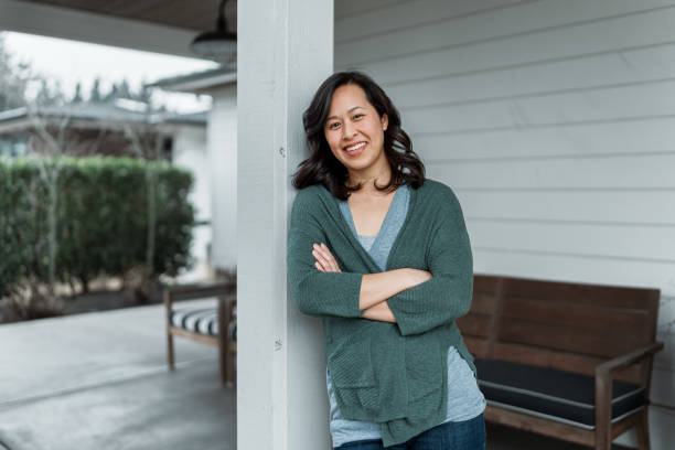 woman on front patio of modern farmhouse style home - etnia vietnamita imagens e fotografias de stock