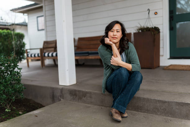 istock Woman sitting on front step of home 1474182260