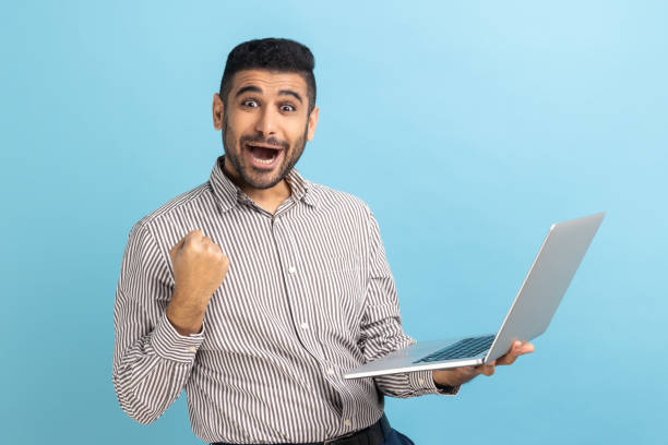 istock Man with beard screaming yes raising hands up, solving hard task, getting access, looking at camera. 1474184516