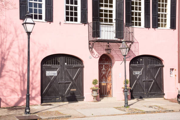 Pink stucco house in full sun on East Bay Street, French Quarter, Charleston, South Carolina. stock photo