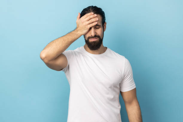 istock Man standing with facepalm gesture, feeling regret and sorrow, blaming herself for mistake. 1474185338