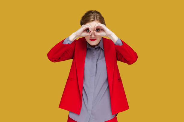 istock Amazed concentrated woman with red lips standing making binoculars with her hands, looking far away. 1474185609