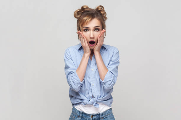 istock Woman grabs face, shocked expression, stares with bugged eyes at camera, cannot believe something. 1474185774