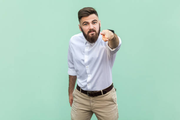 istock Businessman looking at camera with serious expression, pointing at you, expressing anger and hate. 1474186439