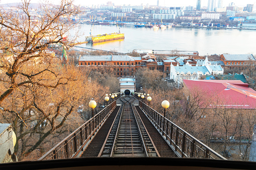 View of funicular rails, Golden Horn Bay and city of Vladivostok, Russia from  cab of funicular on slope of Eagle Hill. Rail transport.