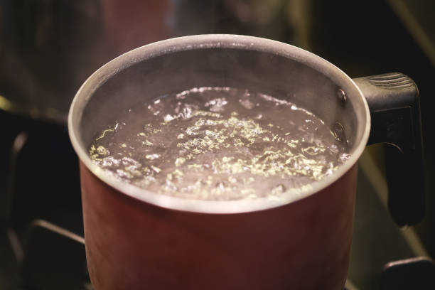istock Water boiling in a kettle over a dark stove. 1474187126