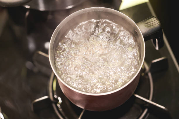 istock Water boiling in a kettle over a dark stove. 1474187131