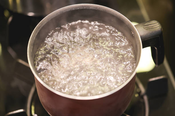 istock Water boiling in a kettle over a dark stove. 1474187149
