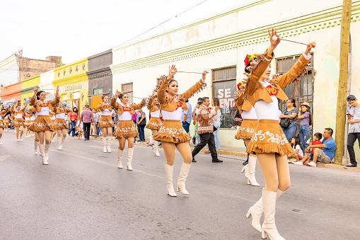 Matamoros, Tamaulipas, Mexico - February 25, 2023: Fiestas Mexicanas Parade, Cheerleaders wearing traditional clothing from the Ricardo Flores Magon High School performing at he parade