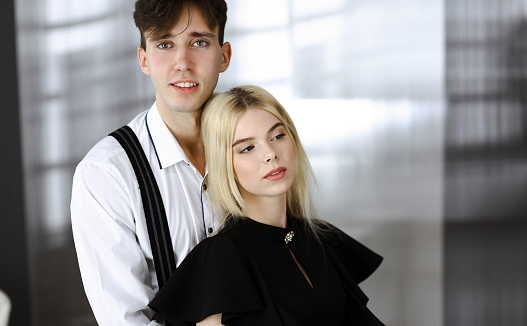 Young couple of businessman and woman are standing in a modern office. Portrait of successful business people.