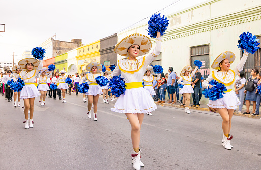 Matamoros, Tamaulipas, Mexico - February 25, 2023: Fiestas Mexicanas Parade, Cheerleaders from the Institute Technological of Matamoros, wearing traditional clothing, dancing at the parade
