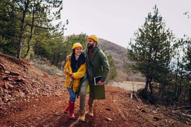 Two young engineers walk along a forest road