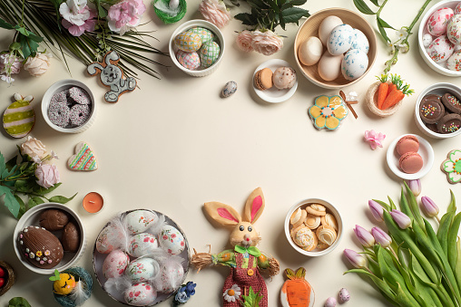 Festive Easter decorations with various holiday symbols. Easter celebration abstract flat lay background with painted eggs,easter bunny,spring flowers and other decorations leaving enough copy space