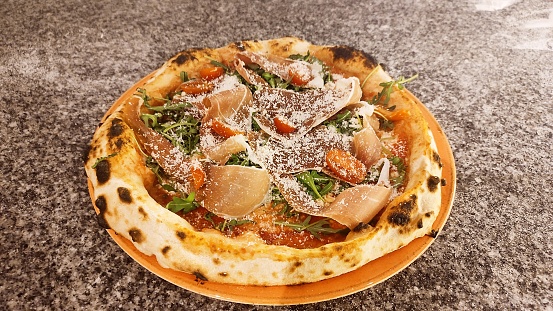 Italia pizza with Parma ham, parmesan cheese and cherry tomato.