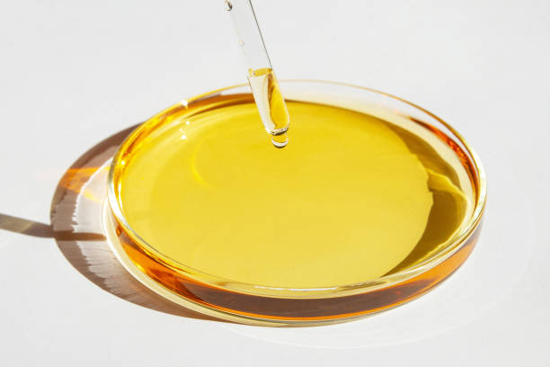 istock Petri dish. With yellow liquid. With solution. Pipette dripping from above. On a white background. 1474199978