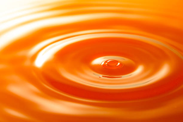 istock macro orange drop,Macro orange water drop texture,Falling drop in orange water with splash,The waves after a few drops of orange juice. 1474203628