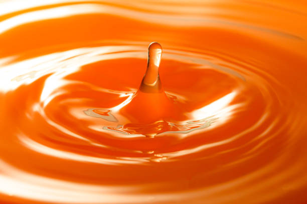 istock macro orange drop,Macro orange water drop texture,Falling drop in orange water with splash,The waves after a few drops of orange juice. 1474203666
