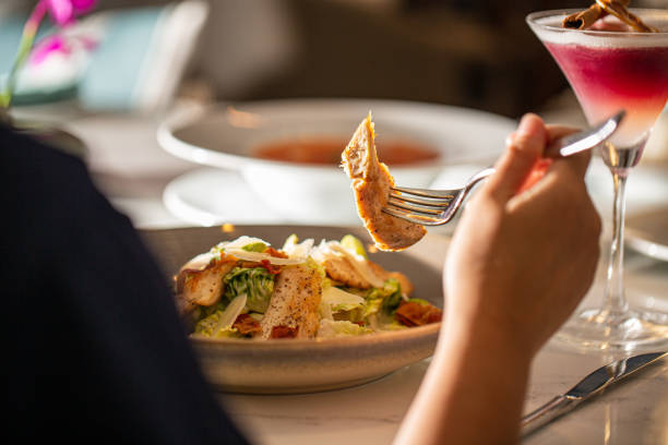 テーブルで食べる女性,レストランでスパゲッティを食べるアジアの若い女性 - silverware lunch table salad ストックフォトと画像