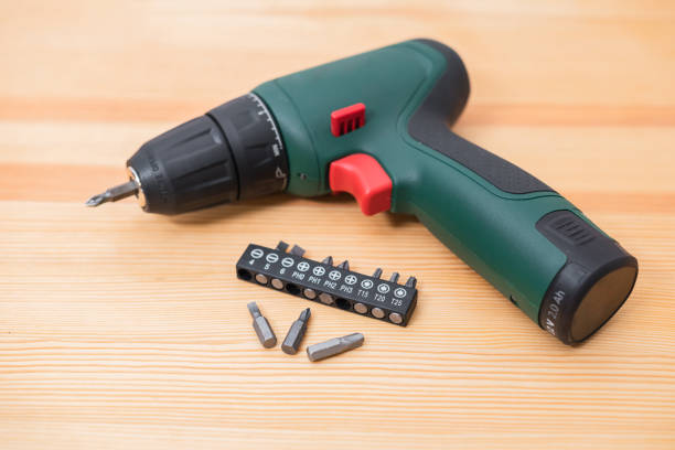 istock electric screwdriver in a man's hand on a white background, as well as on a tree background 1474205168