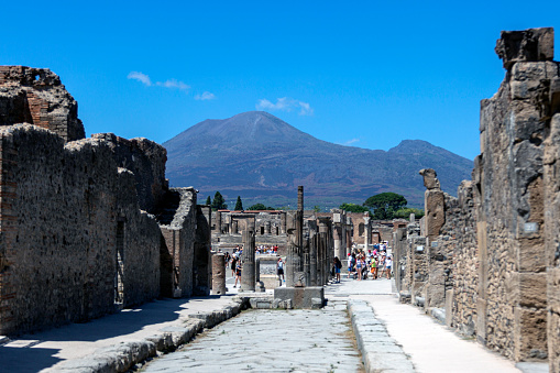 A street in Pompeii with a volcano in the background, the classical Roman city