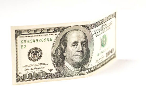 istock 100 dollar bill stands on a white background. 1474206767