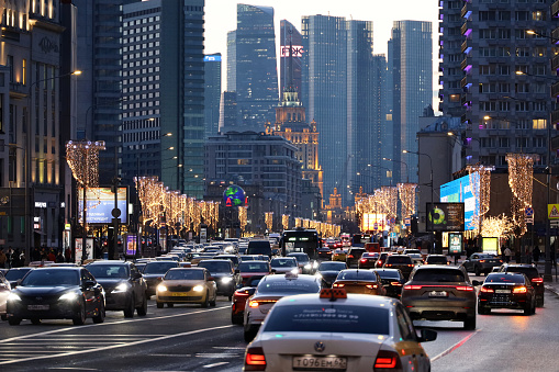 Moscow, Russia - March 2023: Cars in traffic jam on the Novy Arbat street, view to skyscrapers of Moscow city and lights at evening