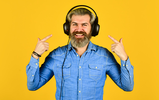 i am happy. Time to relax. brutal hipster wear earphone. singing and dancing. Enjoying his favorite music. Man listening music with his headphones. bearded man hipster in headset. Listening to music.