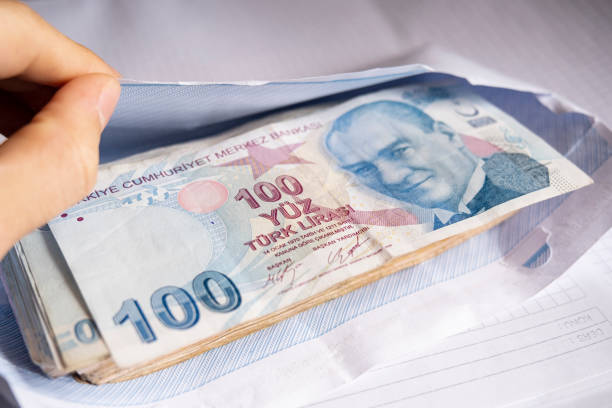 Hand reaching a large number of Turkish liras in the envelope Close-up of the hand reaching a large amount of Turkish lira 100 TL banknotes in the envelope renkli fotoğraf stock pictures, royalty-free photos & images