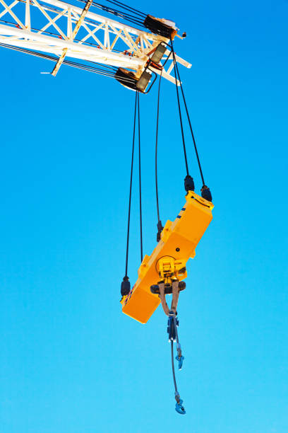 istock Crane boom with a stabilizer and a hook against a blue sky. 1474211265