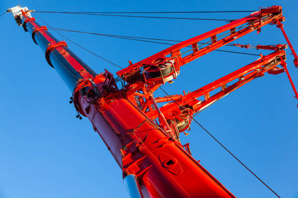 czerwony teleskopowy wysięgnik dużego żurawia samochodowego na tle błękitnego nieba, zbliżenie. - construction equipment large construction crane zdjęcia i obrazy z banku zdjęć