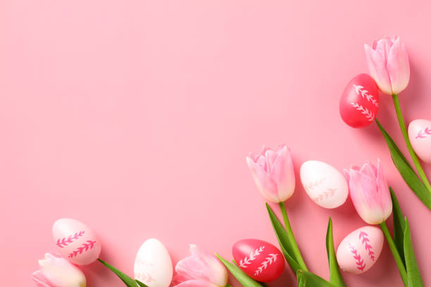 istock Happy Easter concept. Easter greeting card template with colorful Easter eggs and tulips on a pink background. 1474213752