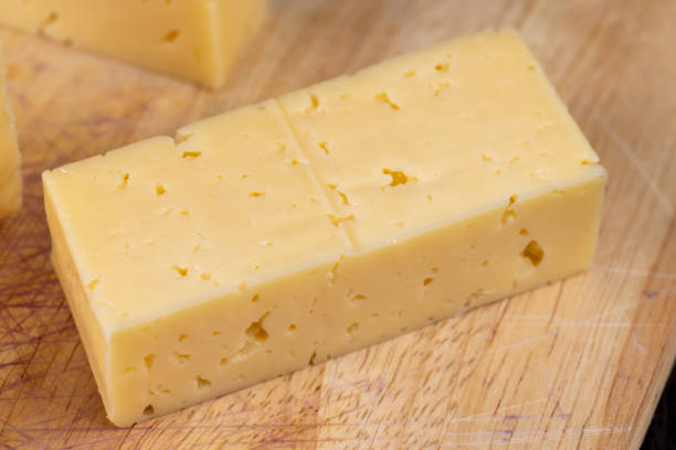 istock Hard cheese with holes cut into thick pieces on a cutting board 1474218020