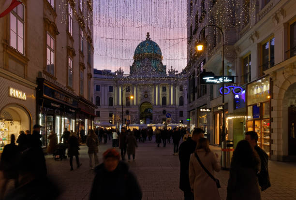 Shopping Street Outside Hofburg Palace in Vienna Vienna, Austria - January 6, 2023: Kohlmarkt, pedestrian luxury shopping street just outside Hofburg palace, crowded with people in the evening city street consumerism window display vienna stock pictures, royalty-free photos & images