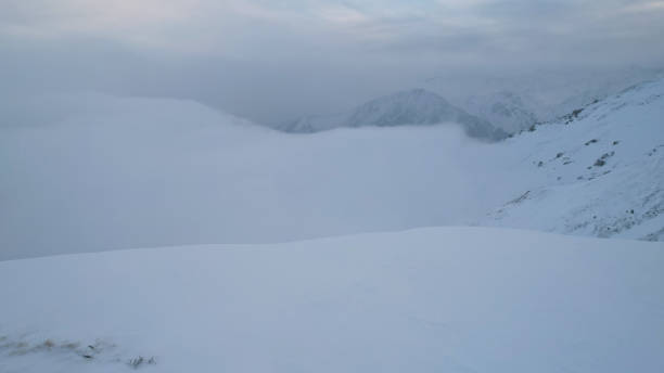 istock Mystical dawn with clouds in snowy mountains 1474220026