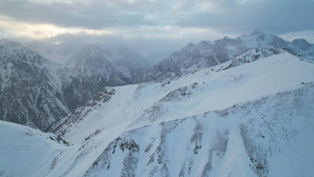 istock Mystical dawn with clouds in snowy mountains 1474220033