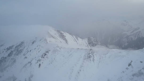 istock Mystical dawn with clouds in snowy mountains 1474220049