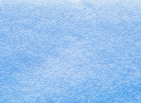 Extremely close-up on foot stone surface. Light blue background macro shot of foot scrub sponge - pedicure stone.