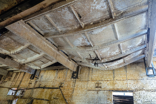 Burnt reinforced concrete roof structures and beams after a fire. Extreme deflection and collapse of ribbed slabs from high temperatures.