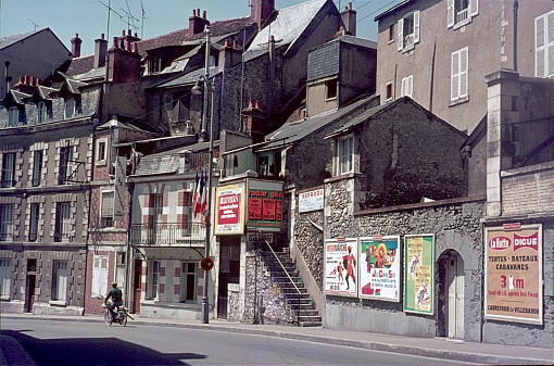 Blois, Loir-et-Cher department, France, 1969. Street scene with residential houses and advertising posters in the French city of Blois. also: a cyclist.