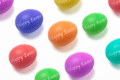Colorful Easter eggs with Happy Easter written on them  on a white surface