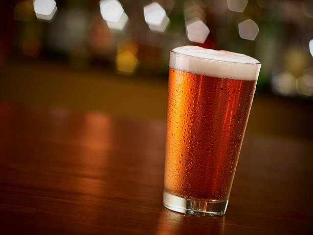 pinta de cerveza en el bar - pint glass fotografías e imágenes de stock