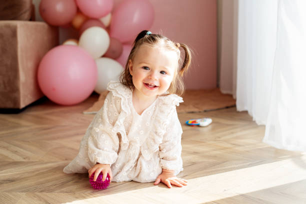 gattonare bambina divertente in casa a casa. il bambino striscia nella stanza e gioca con i giocattoli - baby beautiful caucasian one person foto e immagini stock