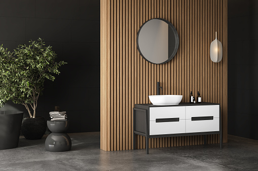 Modern dark bathroom interior with concrete floor, black bathtub and white basin, wooden wall, plant. Minimalist bathroom with modern furniture. 3D rendering