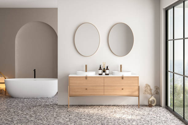 istock Bright bathroom interior with double sink and mirror, terrazzo floor, bathtub, plants. Bathing accessories and modern furniture. 3D rendering 1474229501