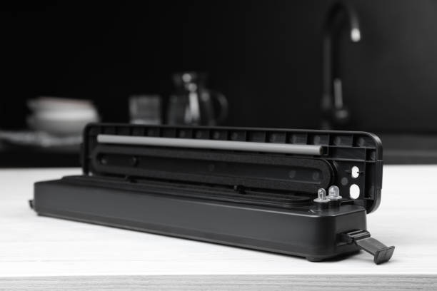 istock Sealer for vacuum packing on white wooden table in kitchen 1474229871