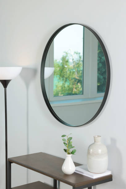 istock Stylish round mirror on white wall over table in room 1474231345