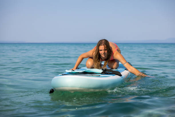 istock Young Caucasian woman having fun while exploring sea with standup paddle board 1474232726